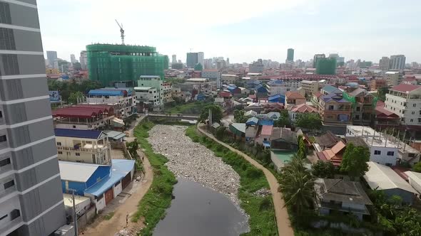 Aerial view of polluted river crossing neighborhood, Cambodia.
