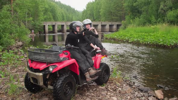 Cheerful Couple Sitting on Quad Bike and Enjoying Scenery in Forest