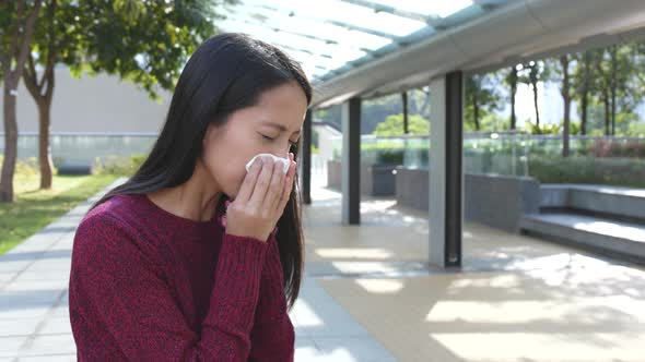 Woman sneeze at outdoor 