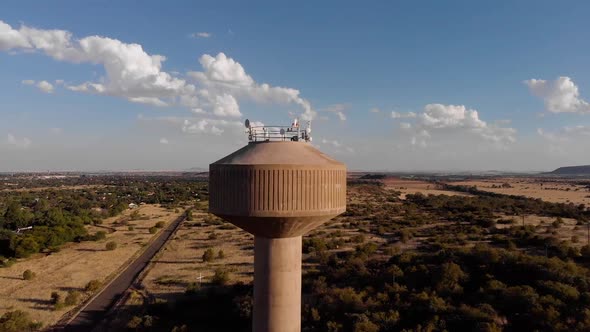 DRONE Circling Shot of a Broadcast Tower in a Rural Area on a Sunny Day