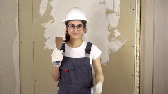A Builder with a Spatula in His Hand Looks at the Camera and Shows the Class and Smiles