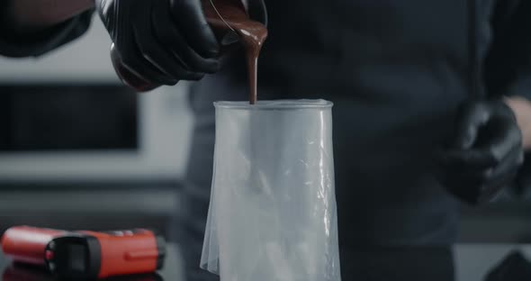 Chef Fills the Pastry Bag with Hot Melted Chocolate in Slow Motion, Raw Materials for Making