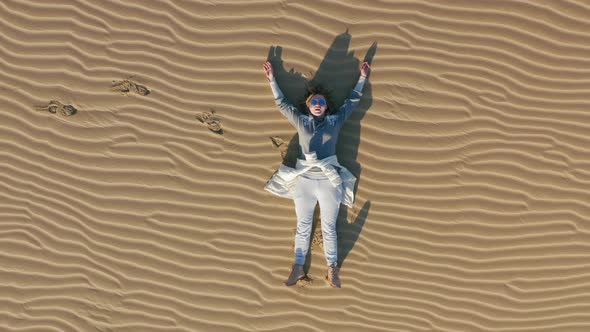  Drone Close Up View of a Woman Relaxing on Sand Dune in the Desert Nature