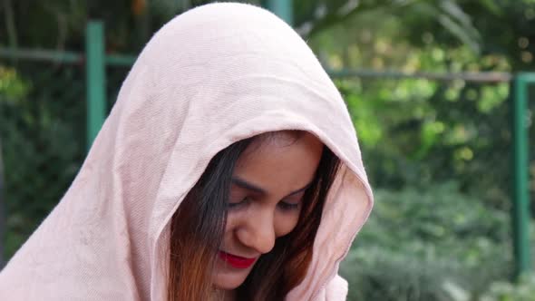 Beautiful Indian woman smiling while looking down.