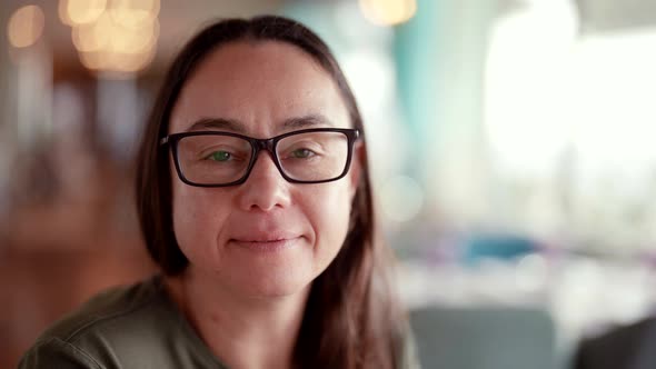 Closeup Portrait of a Beautiful Adult Woman with Glasses Looking Calmly Thoughtfully at the Camera