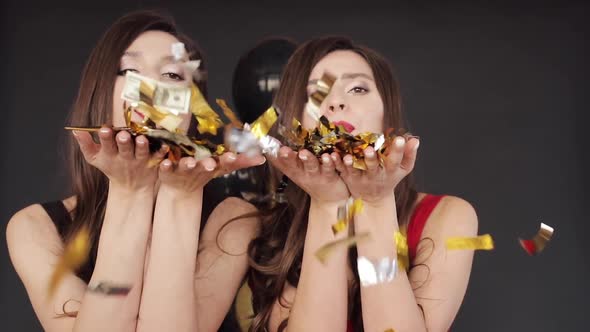 Two Attractive Sisters Giving Air Kiss To Camera