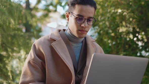 Confident Arabian man working with laptop