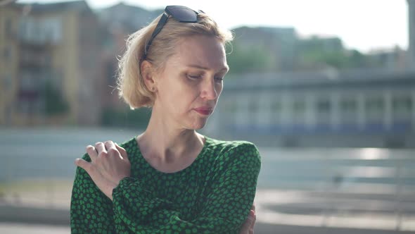 Portrait of Sad Lonely Caucasian Adult Woman Standing on Sunny City Street Thinking