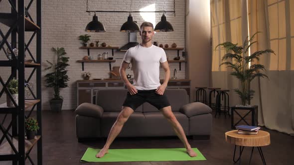 Joyful Athletic Man Doing Yoga Exercises at Home