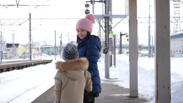 Asian Children Waiting Express Train On Railway Station Platform,Winter Travel Concept