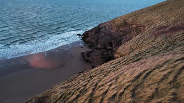 AERIAL: Slow dolly towards beach over coastal cliffs, Blue Pool Bay, 4k Drone