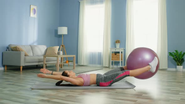 Young Slim Woman Practices Pilates at Home