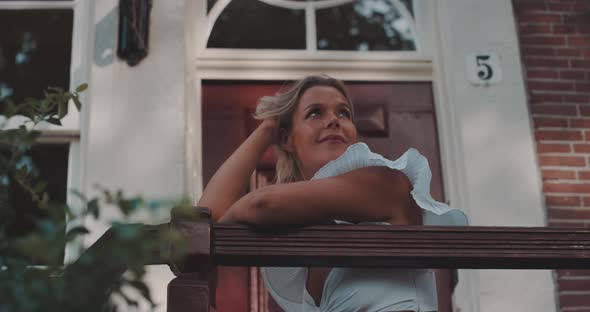 Woman smiles while sitting on doorstep