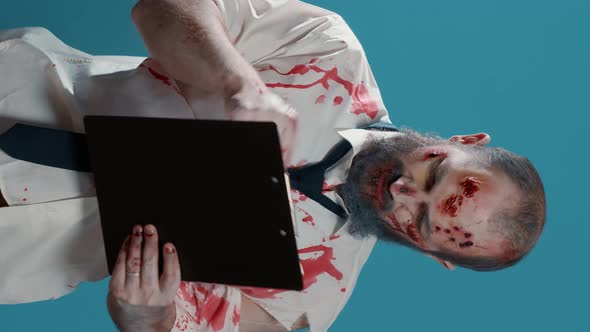 Vertical Video Heavy Wounded Scary Zombie Signing Delivery Documents on Clipboard