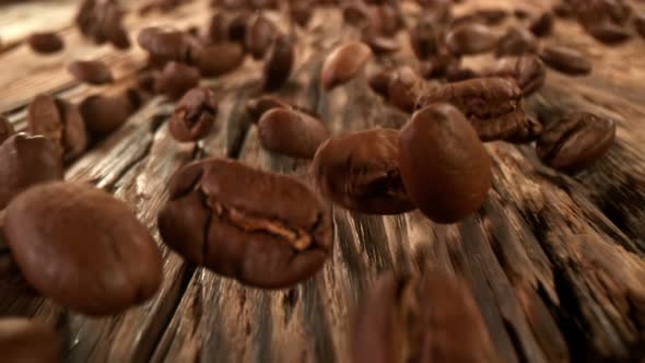 Super Slow Motion Detail Shot of Coffee Beans Strewing Towards at 1000Fps with Camera Motion