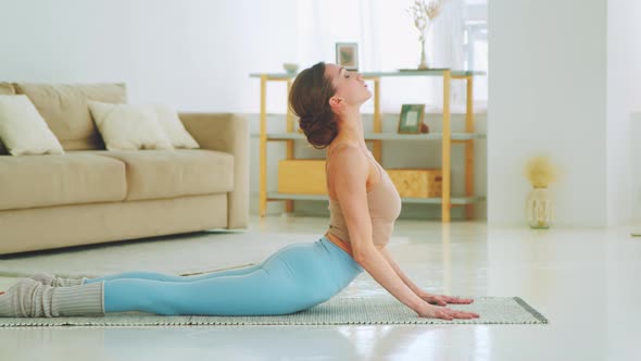 A young girl doing yoga in the bhujangasana pose. Attractive girl doing static exercise