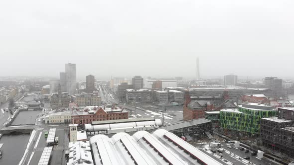 Drone flying over Malmö Central Station in snow. Turning torso, Clarion Hotel in background