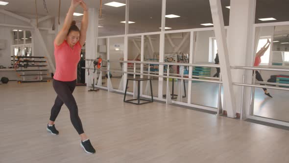 A Young Girl Does Gymnastic Exercises in the Gym Forward Somersaults on Straight Arms and Laughs