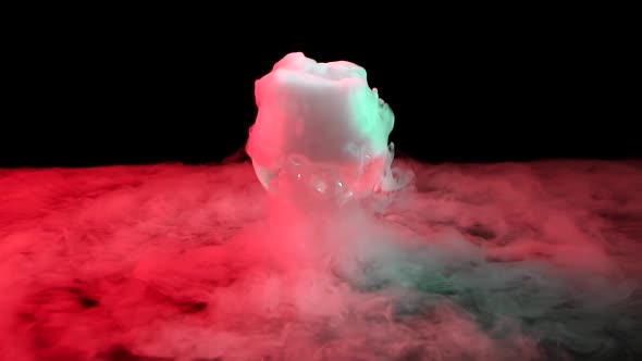 Cognac Glass with the Effect of White Smoke Dry Ice at Black Background with Red Light. Slow Motion