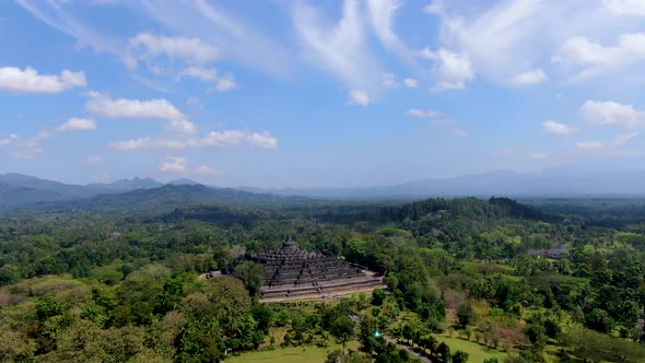 Iconic Buddhist temple Borobudur, Indonesia surrounded by tropical forest aerial