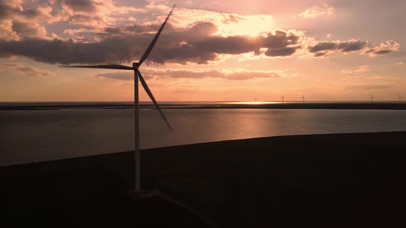 Aerial View of Wind Turbines and Agriculture Field Near the Sea at Sunset