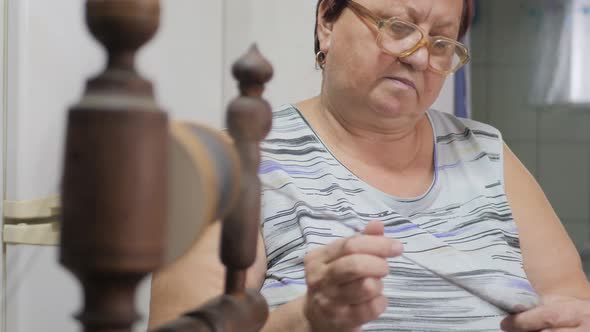 Woman Preparing Yarn To Knitting. Hand of Woman Weaving and Spinning Natural Yarn. Crafts and