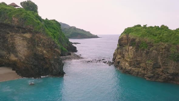 Drone Flight Over a Hidden Exquisite Tropical Blue Lagoon with Green Cliffs