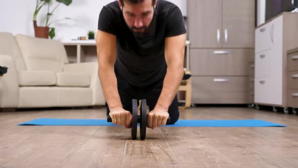 Fit Man Using an Ab Wheel for Exercises