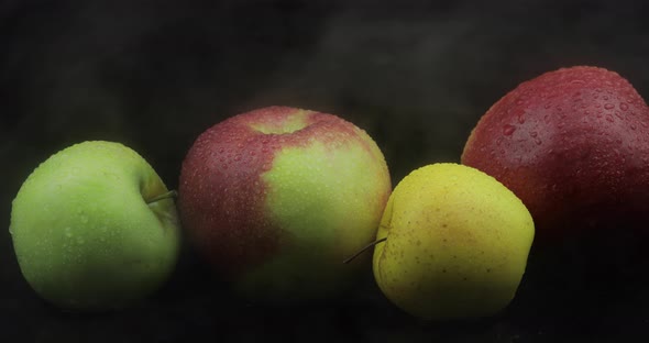 Tropical Fruit Apple in Cold Ice Clouds of Fog Smoke on Black Background