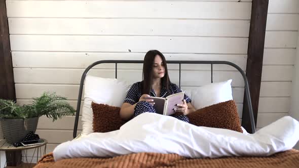 Girl reading a book while lying in bed