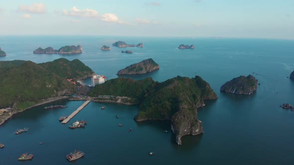 Aerial: flying over Cat Ba island at dusk, Ha Long Bay unique limestone peaks in the sea Vietnam