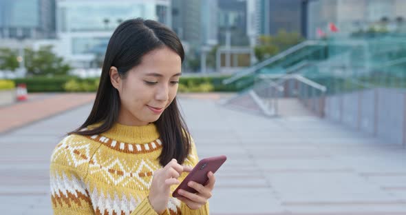 Asian Woman Use of Mobile Phone in City 