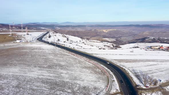 Aerial View of a Winding Road With Driving Cars in a Frosty Winter Sunny Day