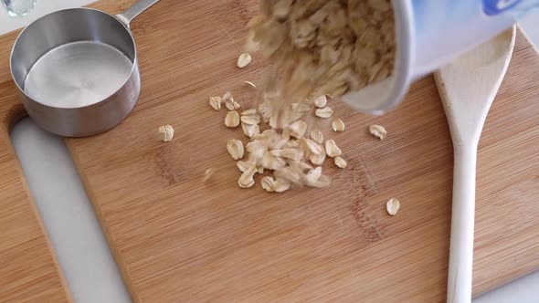 A pile of oats grain cereal being poured with kitchen utensils for a healthy oatmeal breakfast TOP D