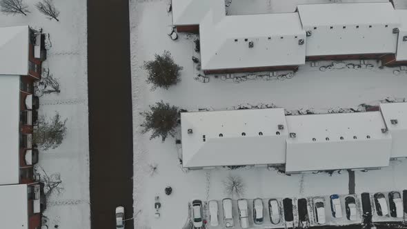 Aerial view over snow covered city street and houses in snow winter road covered