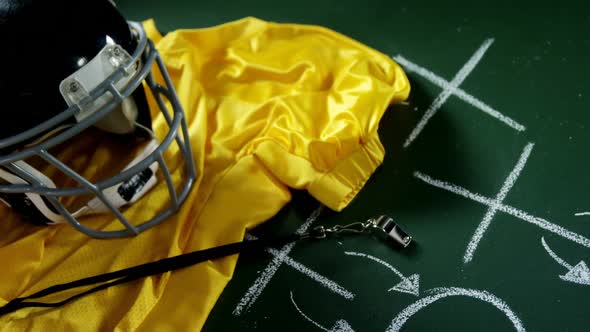 Jersey, referee whistle and head gear on green board