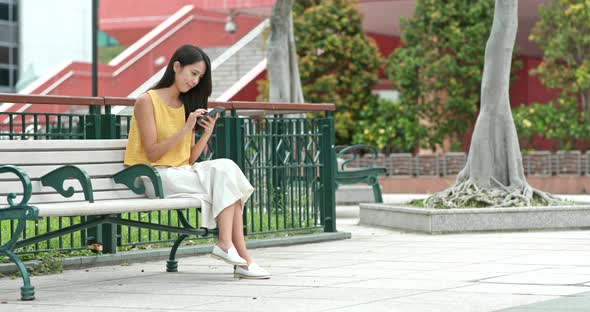 Woman use of cellphone at outdoor park