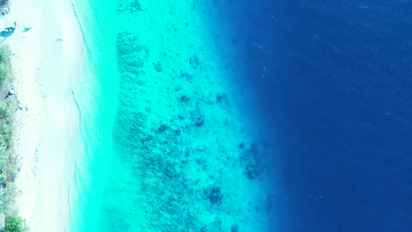 Tropical overhead copy space shot of a sunshine white sandy paradise beach and aqua blue water backg