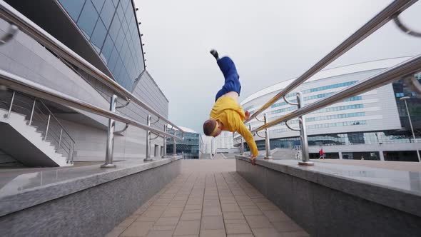 Free Running Young Man Runs Over Obstacles in the City and Doing a Flips on Training Area Near