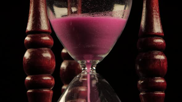 Sand Falls in a Hourglass. Black. Close Up