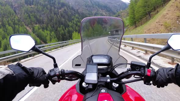 Motorcyclist on Motorbike Rides on a Beautiful Landscape Mountain Road Near Swiss Alps