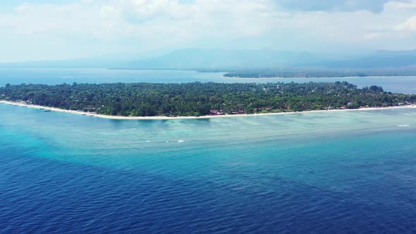 Wide angle overhead tourism shot of a sandy white paradise beach and aqua turquoise water background