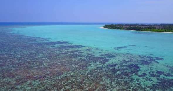 Natural above tourism shot of a sandy white paradise beach and blue sea background in 4K