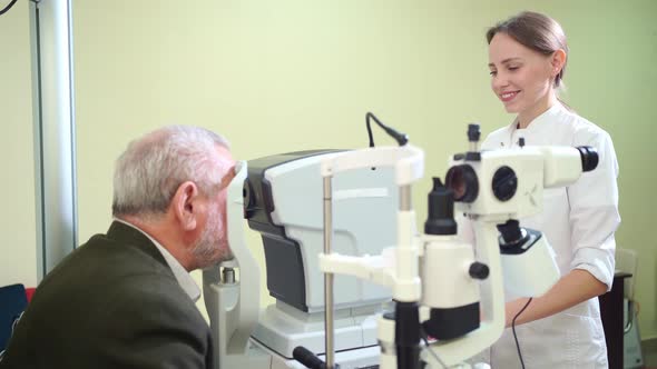 Doctor Examines Elderly Man's Eye on Screen of Autorefractometer