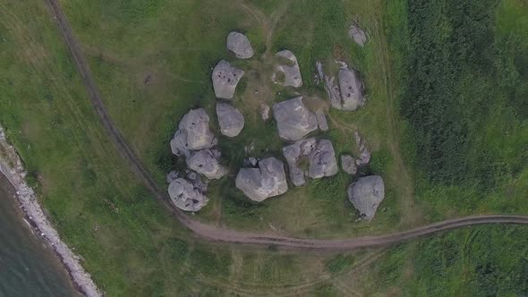 Top down Aerial view of Huge stones (rocks) in a vast field by the lake