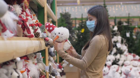 Young Woman Touches White Snowman Toy with Long Legs