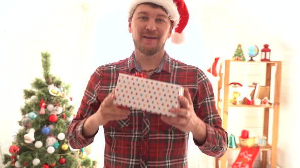 A Man in a Plaid Shirt Gives a Christmas Present