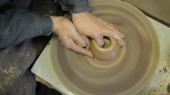 Potter Forms a Clay Product with Pottery Tools on a Pottery Wheel, Top View.