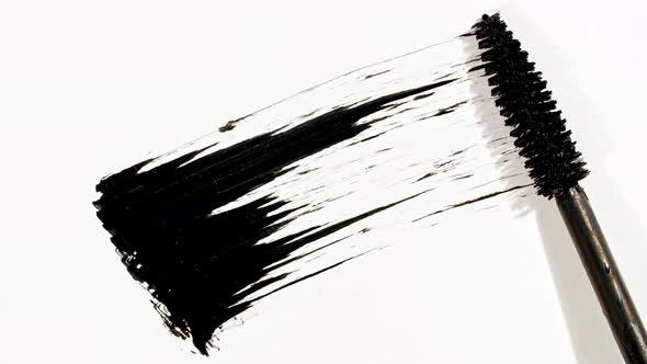 Macro Shot and Slow Motion of a Black Mascara Isolated on White Background