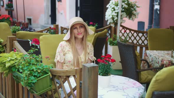 Smiling Woman in Outside Restaurant. Cheerful Young Young Lady Sitting at Table in Outside